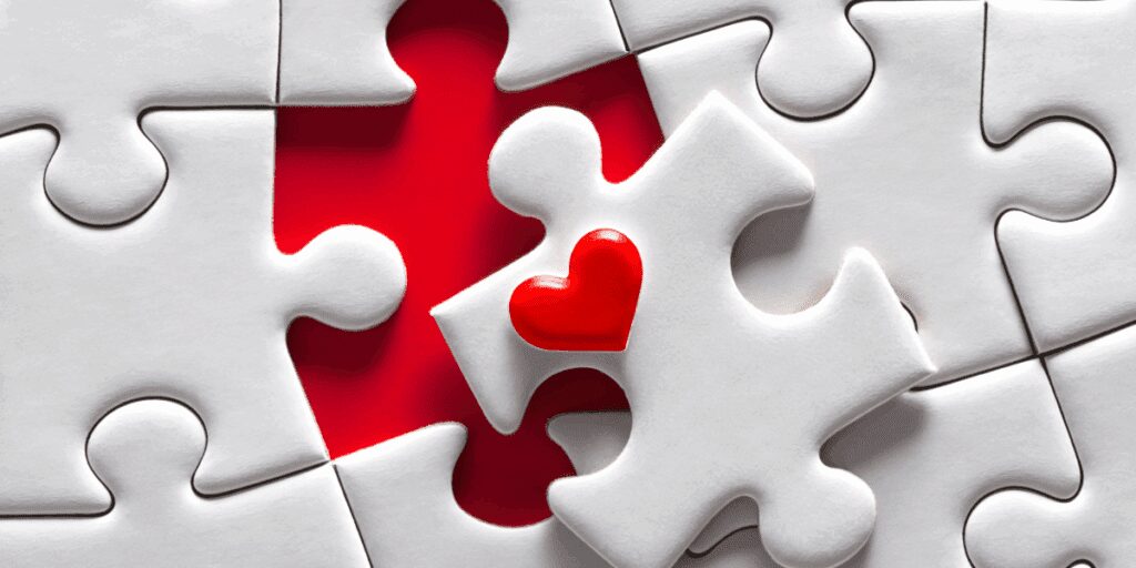 red heart shaped puzzle piece among white pieces