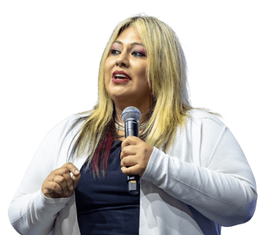 A woman with blonde hair speaking into a microphone.