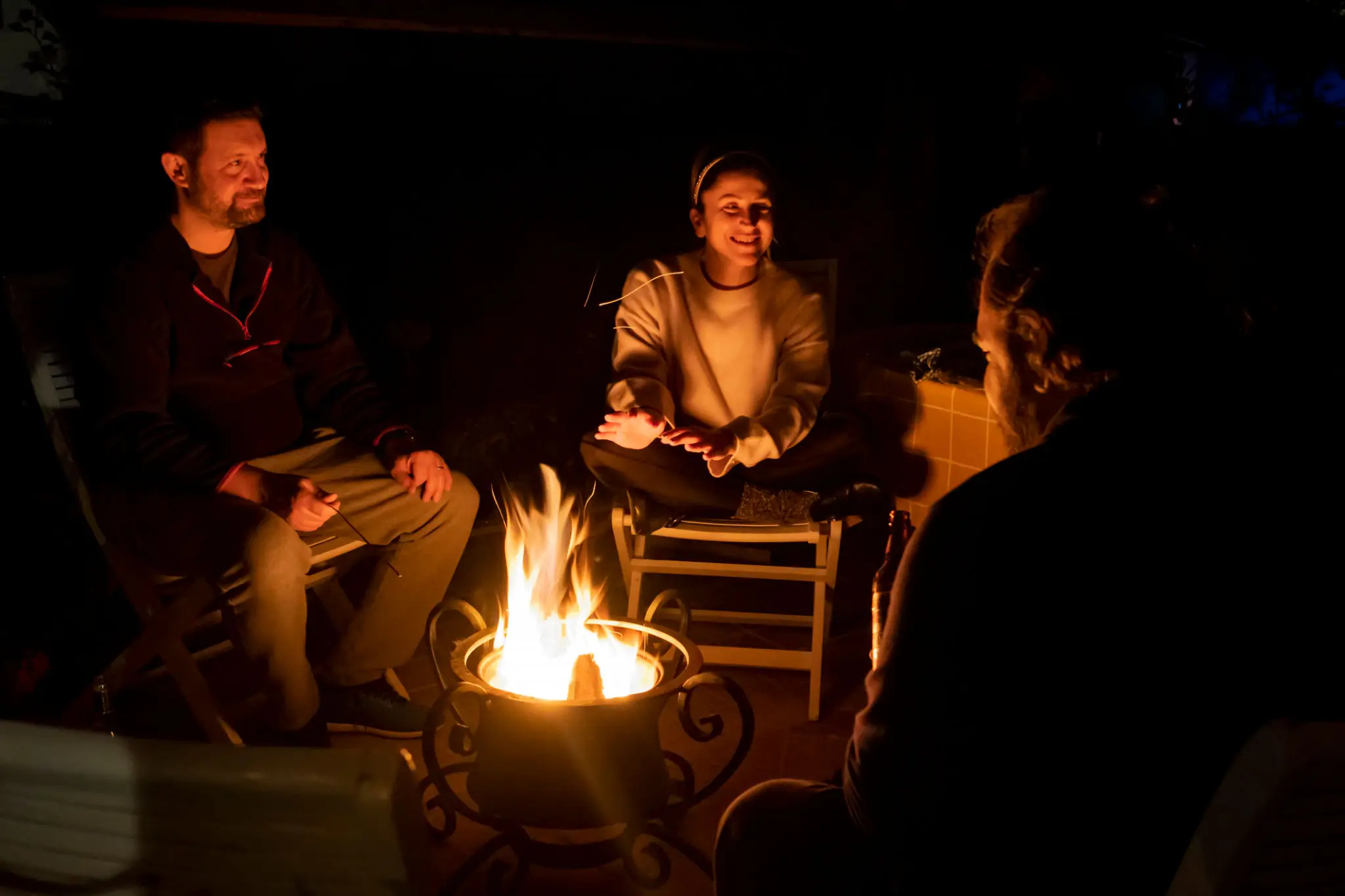 People sitting around a campfire at night.