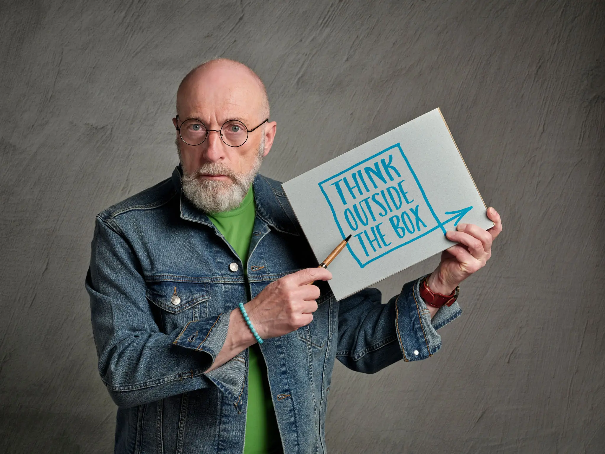 Man holding "Think Outside the Box" sign.