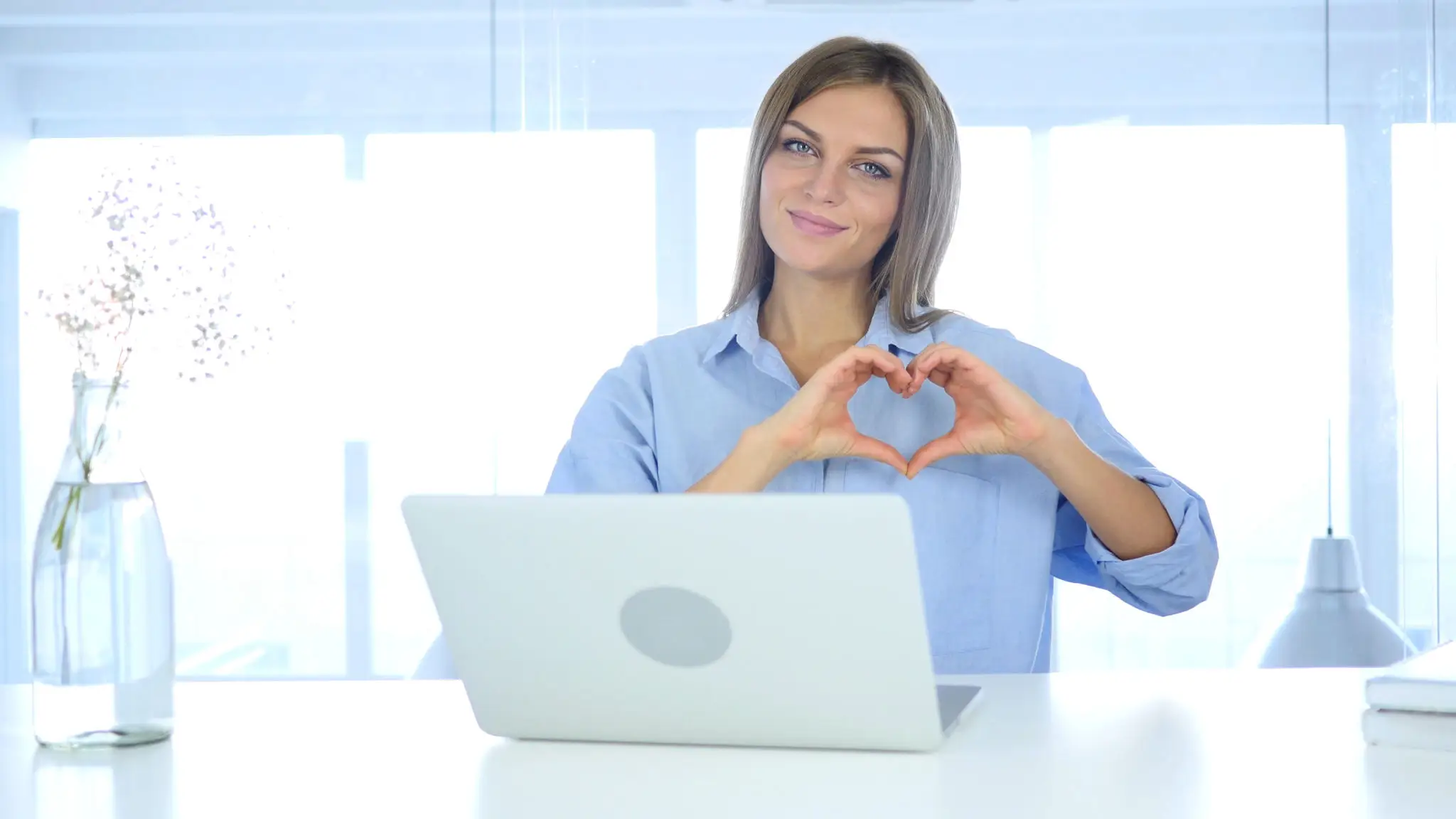 Woman making heart shape with hands.